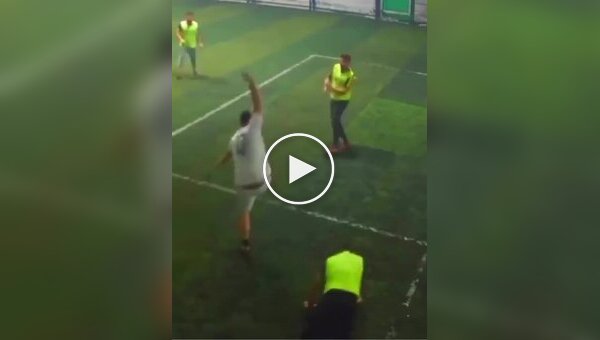 Любители мини-футбола пытаются забить мяч в ворота